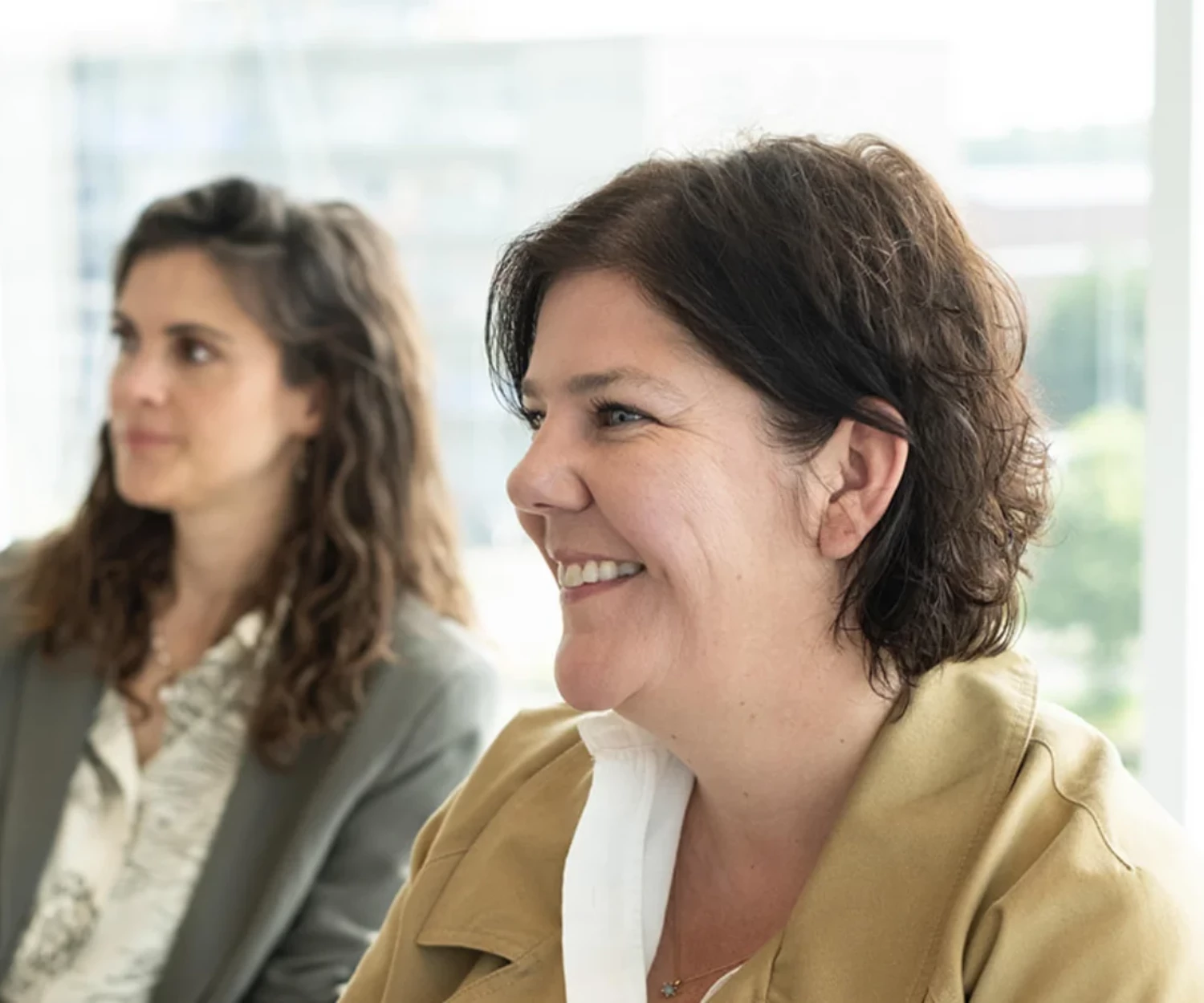 Two women smiling during a meeting.