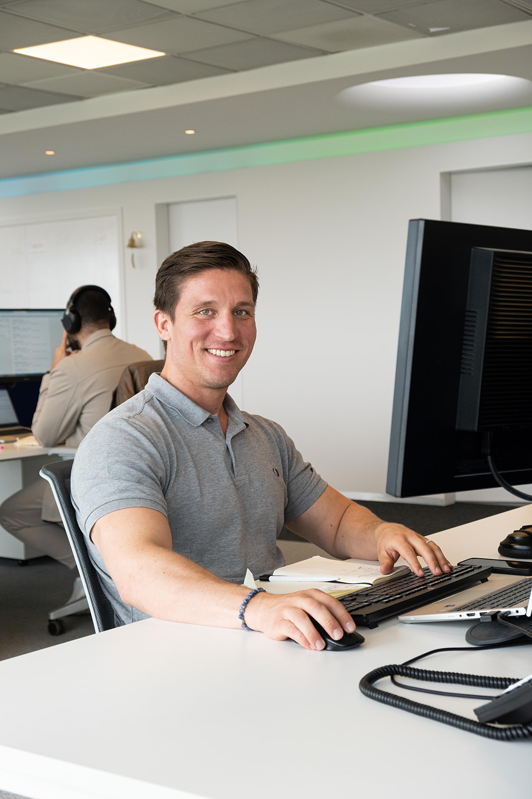 Male coworker smiling while sitting at his desk.